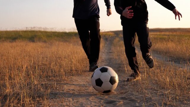 Father and son playing soccer on sunny field, running and enjoying active time together. Fatherhood, bonding and healthy lifestyle, outdoor parenting and emotional connection through sport. Family