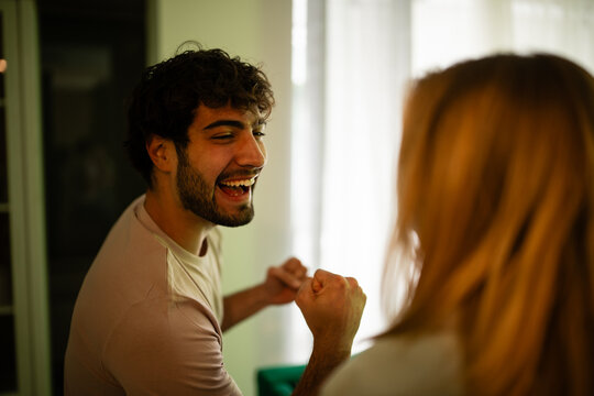 Young man laughing and celebrating with a woman