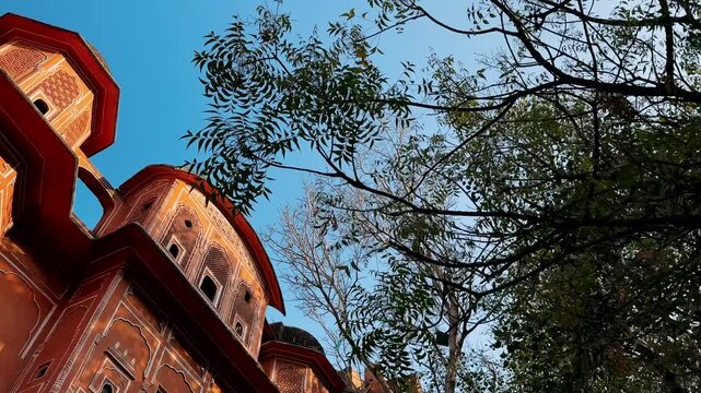 A Glimpse of Architectural Grandeur: The Majestic Facade of an Ornate Building Surrounded by Nature's Touch in a Serene Sky Setting