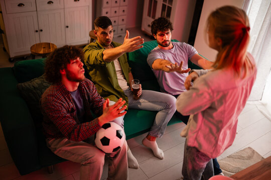 Friends preventing woman interrupting soccer game