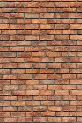 Fototapeta premium Textured rustic orange and brown brick wall surface close-up