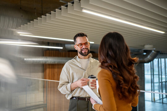 Employees communicating during coffee break in modern office