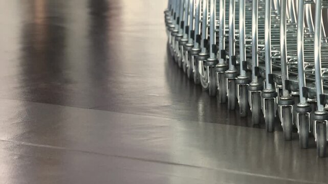 Airport luggage trolleys stacked and moving for passenger use