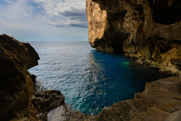 Fototapeta premium Stairs carved into a cliffside leading down to Neptune's Grotto in Sardinia, Sassari Province, Italy - background or wallpaper