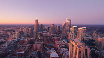 Obraz premium A stunning aerial view of a modern city at sunset, showcasing the skyline with soaring skyscrapers and a vibrant horizon painted in warm hues