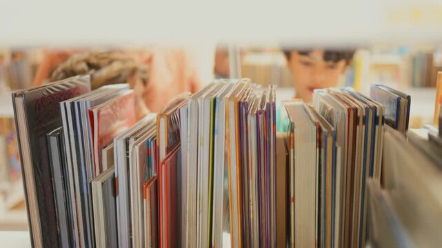 Curious children searching for books on a white shelf in a library, a close-up perspective from between shelves showing kids reading and selecting stories for education and fun