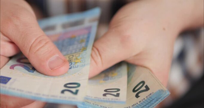 Counting money and income. Flipping through euro banknotes in a bundle with hands.