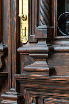 Brass door handle on carved wooden entrance, restored historic door detail, Odesa Ukraine