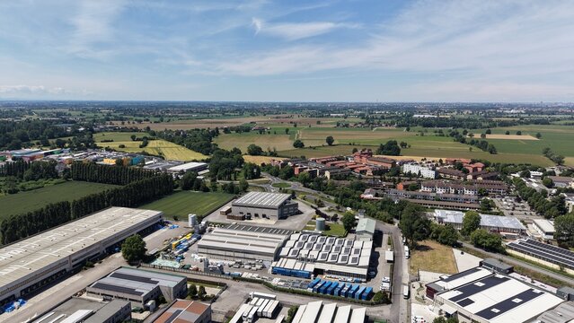 Aerial View of Industrial Park and Rural Landscape: An expansive aerial perspective showcases a sprawling industrial complex adjacent to cultivated fields and distant town.