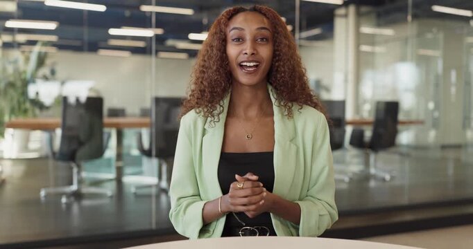 Businesswoman in office giving online video presentation. Engaging speaker on camera for live webinar and remote meeting. Shares insights for clients and teams. Clear corporate message.