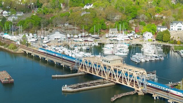 NextGen Acela train in Mystic aerial view, a high-angle drone tracking shot following Amtrak&rsquo;s new high-speed Alstom Avelia Liberty trainset across the swing truss bridge in Mystic Connecticut.