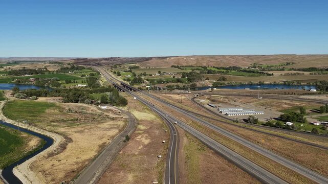 Aerial of Interstate 84 through rural town Glenns Ferry Idaho along Snake River in spring