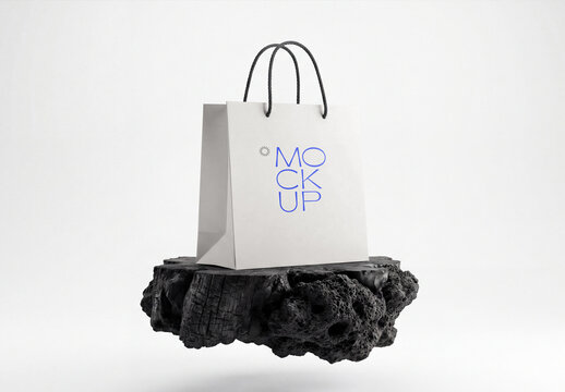 Minimalist Paper Shopping Bag Mockup Levitating Above Black Charcoal Rock Podium for Luxury Brand Packaging