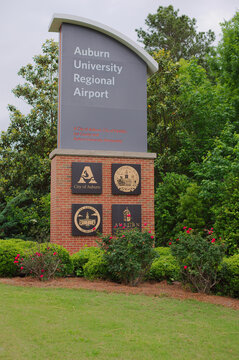 Auburn University Regional Airport Entrance Sign With City Seals and Landscaping.Editorial Use Only Auburn, AL USA May 12, 2026. featuring city and county seals, manicured shrubs and roses, set agains