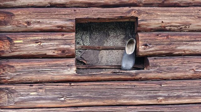 Old rubber boot on a window sill of a rustic wooden log house