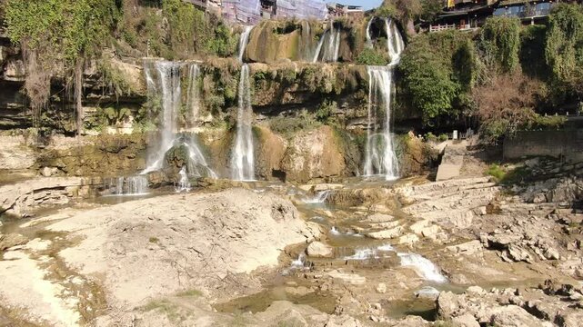 Multilevel Waterfall Over Rocky Cliff in Lush Nature