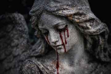 Obraz premium Weeping angel statue with blood tears symbolizing sorrow and human suffering