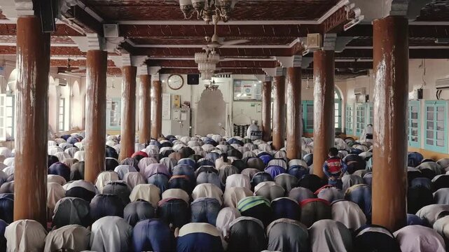 Large group of Muslim men praying together in a mosque during prayer time