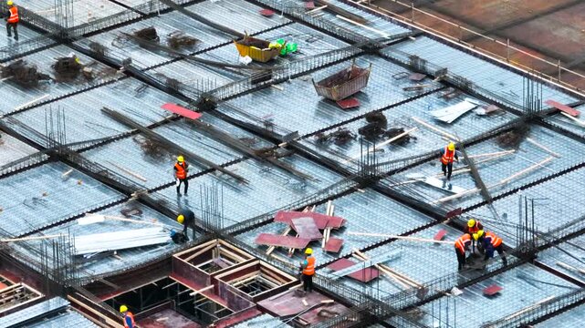Construction Workers on High Rise Building Floor with Rebar and Metal Decking