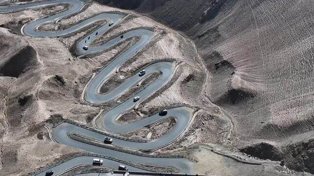 Aerial View of Cars on Winding Mountain Switchback Road in Arid Landscape