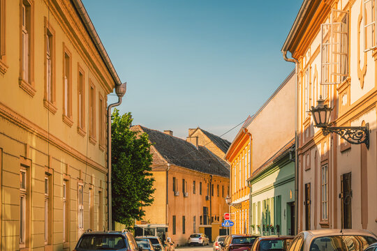 Sunlit historic european street with colorful facades and parked cars in small town of Petrovaradin in Serbia