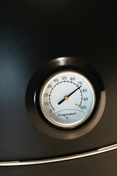 Analog temperature gauge close-up showing high heat level.Close-up of an analog temperature gauge with a classic dial showing a high temperature reading in Celsius. Industrial measuring instrument use
