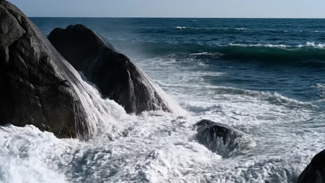 Ocean waves crashing against rocky coastline creating splashing water effect