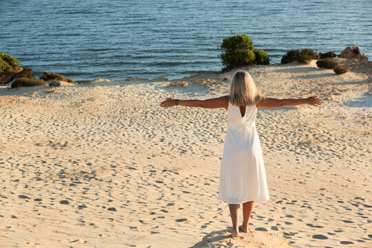 Mujer joven meditando en la playa.