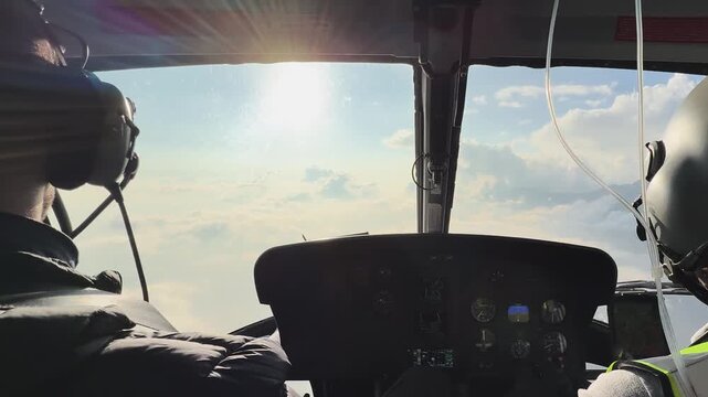 Helicopter cockpit view flying above clouds