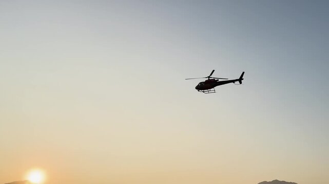 Helicopter flying low during golden hour sunset