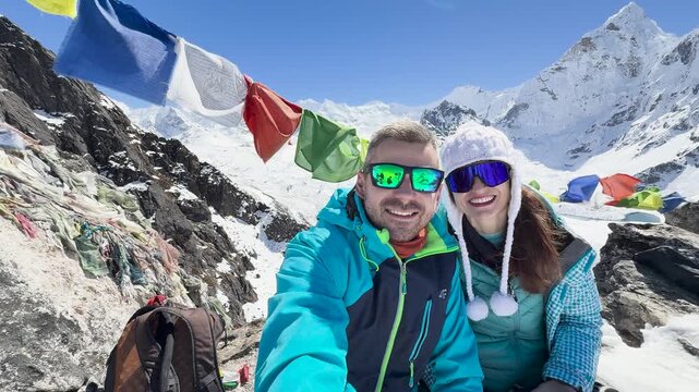 Couple selfie with Ama Dablam and prayer flags in Himalayas, Nepal