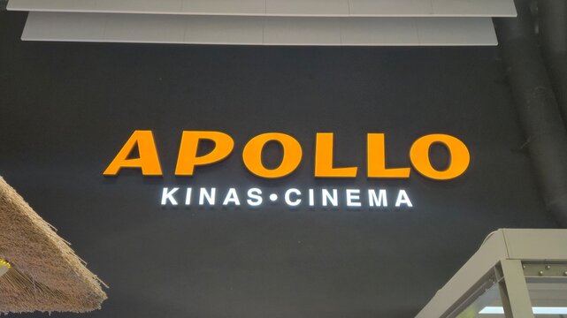 Vilnius Lithuania 09.05.2026 Apollo cinema illuminated sign inside modern shopping mall with entertainment branding, orange lettering and contemporary commercial interior design