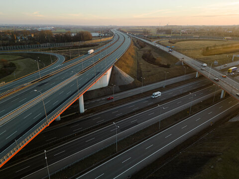 Aerial drone view of a major highway junction in Poland. A1 and A4 motorway interchange with traffic and overpasses during sunset in Gliwice.