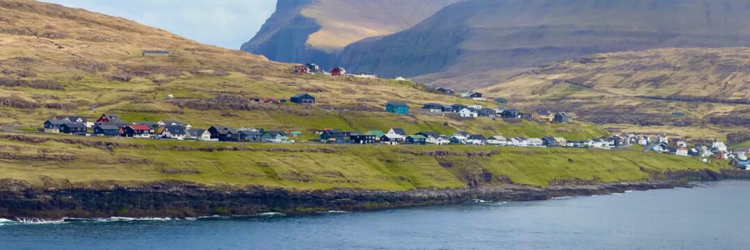 Panoramic view of the village of Eidi on the north-west coast of Eysturoy with the Sundini fjord and Risin og Kellingin sea stacks, Faroe Islands