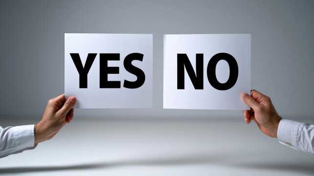 Hands holding large signs displaying the words "YES" and "NO" in bold black letters against a neutral gray background with soft lighting