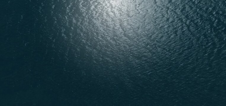 Moody aerial texture of deep navy ocean water with subtle natural light on gentle ripples. Excellent for cinematic backdrops, corporate website headers, minimalist designs, and calming visual themes.