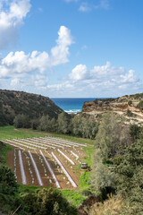 Naklejka premium Coastal farmland between rocky cliffs and sea