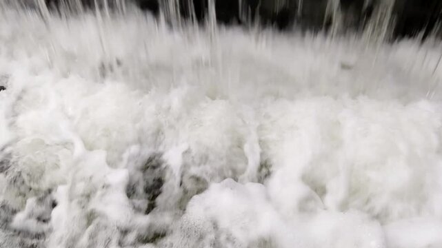 The water turns into a seething foam at the foot of an artificial waterfall. For background visuals and scenic video footage for digital media.	

