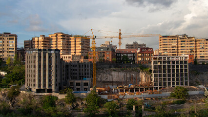 Fototapeta premium Construction crane working on an urban development project in Yerevan, Armenia, highlighting the mix of modern and historical architecture.