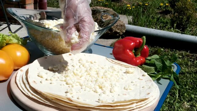 the process of cooking pita bread with cheese yellow tomatoes in sunlight cooking pita bread for lunch. High quality 4k footage