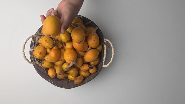 Hand holding loquats. Yellow fruit hand. medlar in hand, close-up. High quality photo
