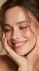Obraz premium Portrait of a joyful young woman with flawless skin smiling gently with closed eyes and hands cradling her face in a serene moment of happiness and peace