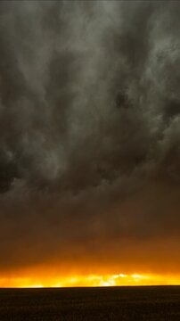 Moody thunderstorm clouds rolling through a golden sunset storm sky scene
