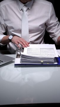 Businessman auditor studying financial report data with laptop and pen, conducting detailed audit and analysis. Audit and taxes in business