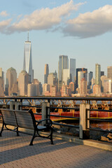 Obraz premium Illuminated Seat Along Waterfront Enjoying Peaceful Cityscape And Gentle Shadow Play new york