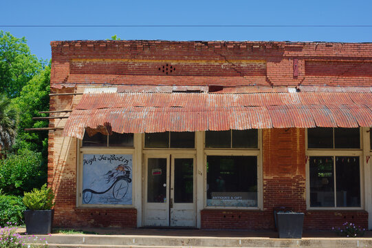 Historic Red Brick Storefronts on Small Town Main Street With Vintage Architecture on a Quiet Summer Afternoon Editorial Use Only Parrot, GA,  USA, May 14, 2026 vintage architectural details, a covere