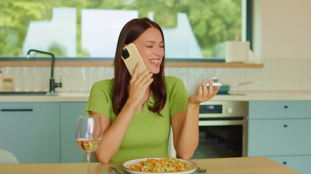 Happy young woman talking on smartphone during dinner, dynamic 4K slow motion
