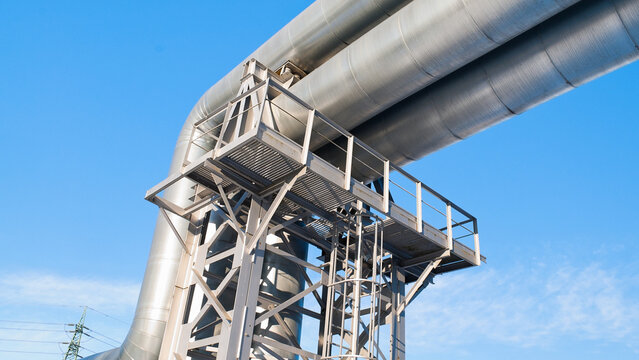 A close-up of a pipeline with a blue sky in the background