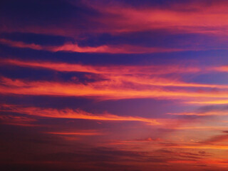 Fototapeta premium Beautiful dramatic sunset sky with vibrant orange pink and purple clouds over a dark twilight horizon
