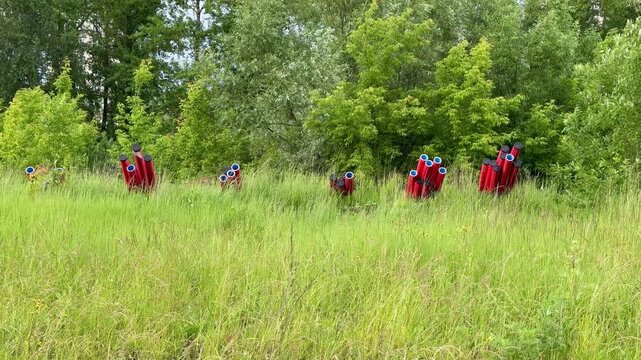 Plumbing connection of residential area. Red plastic water pipes coming out of the grassy soil, closed fittings and valves are visible, bright red protective sleeves, check readiness for connection